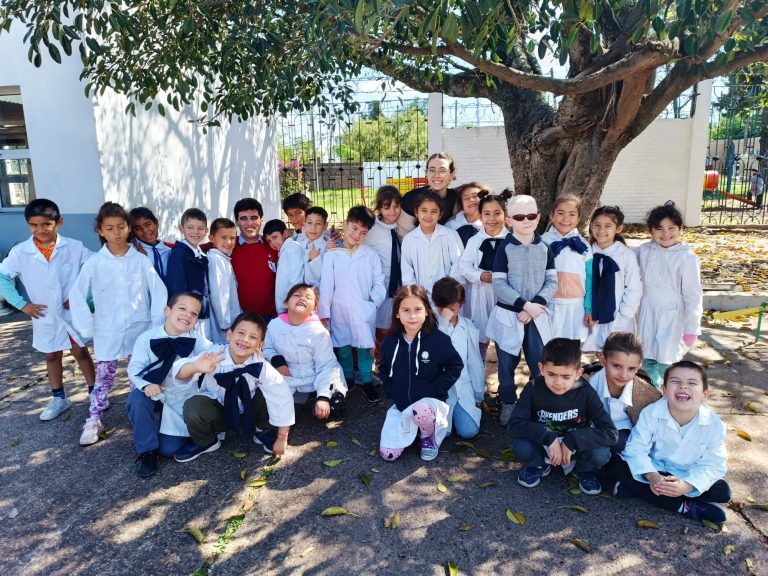Foto grupal de promotores y niños con los carteles o durante la actividad al aire libre